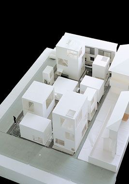 an architectural model of a house with white walls and floors, in the middle of a black background