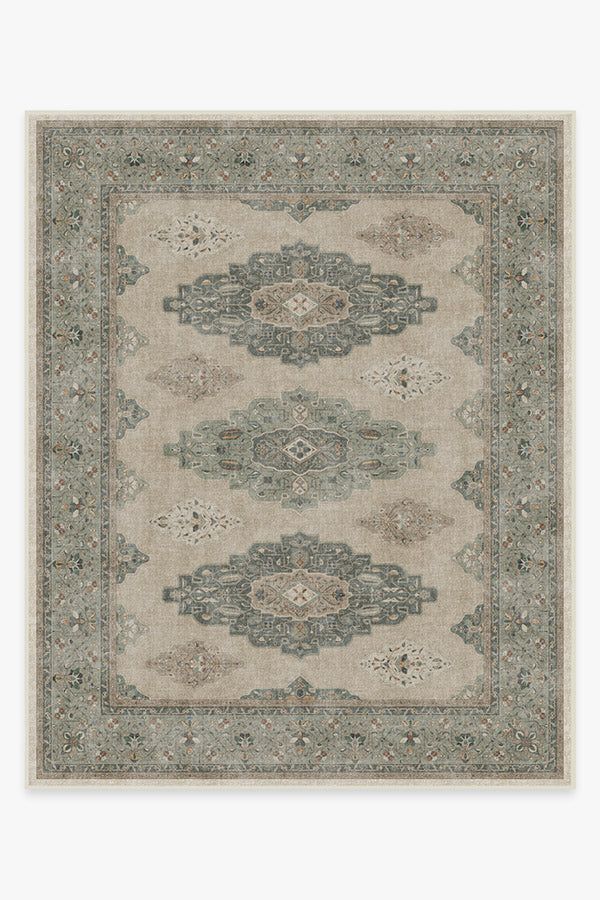 a rug with an ornate design on the front and back side, in grey tones