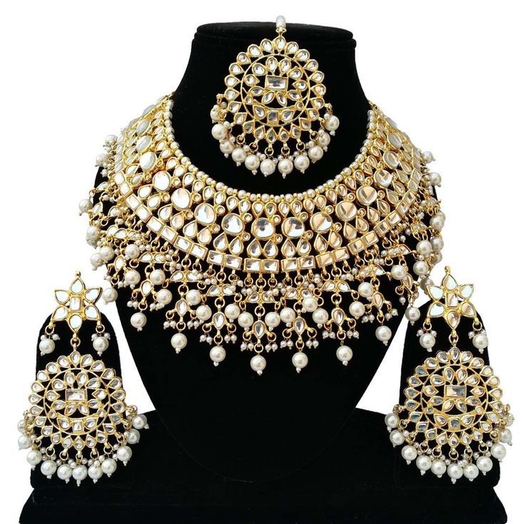 a necklace and earring set with pearls on the neck, along with matching earrings