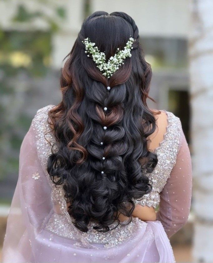 the back of a woman's head with long hair and flowers in her hair