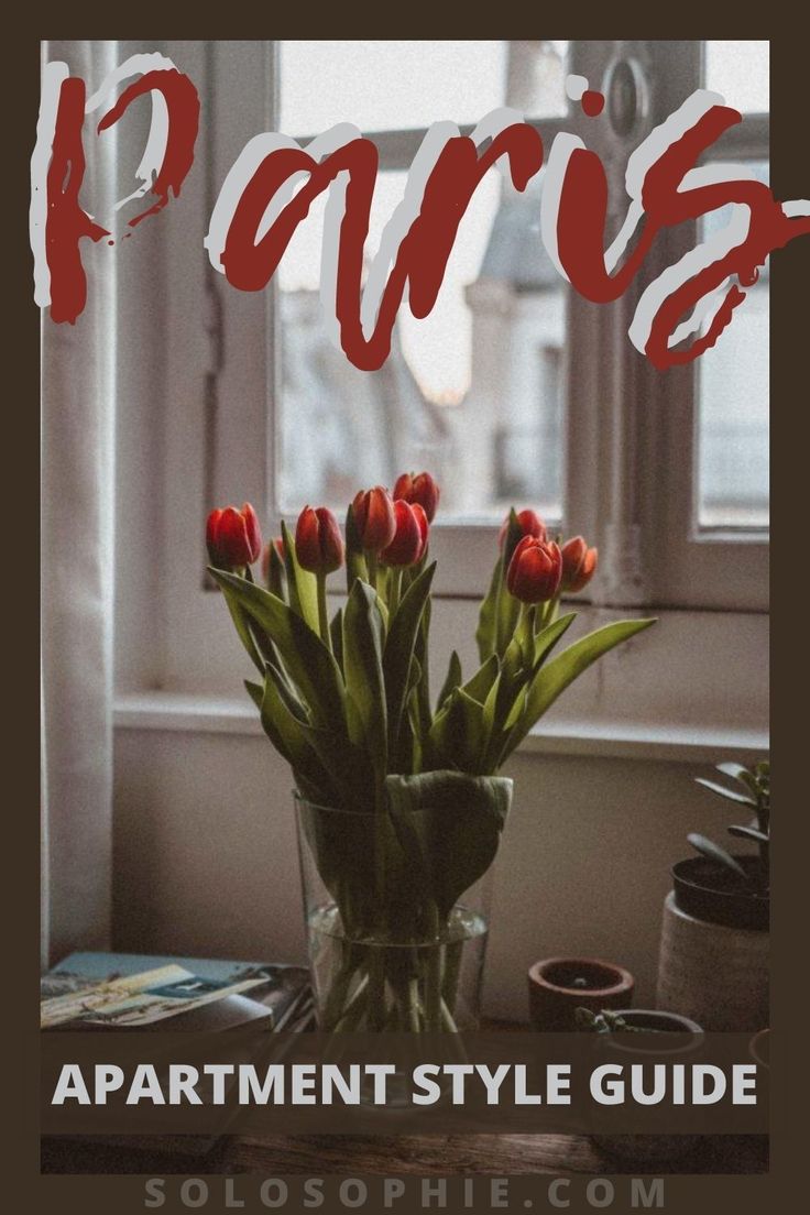 a vase filled with red tulips sitting on top of a table