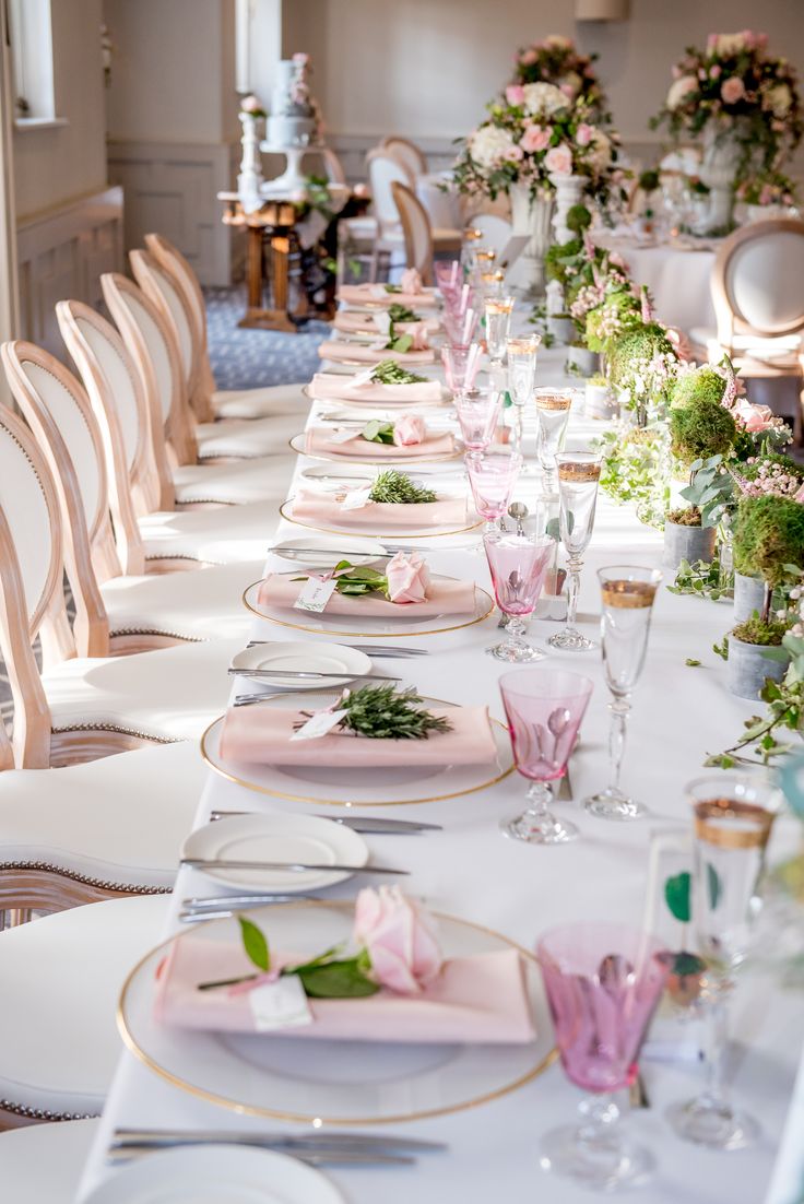 the table is set with pink plates and place settings for an elegant dinner or bridal party