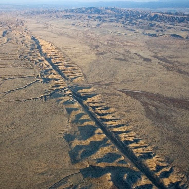 an aerial view of a dirt road in the middle of nowhere, with no cars on it