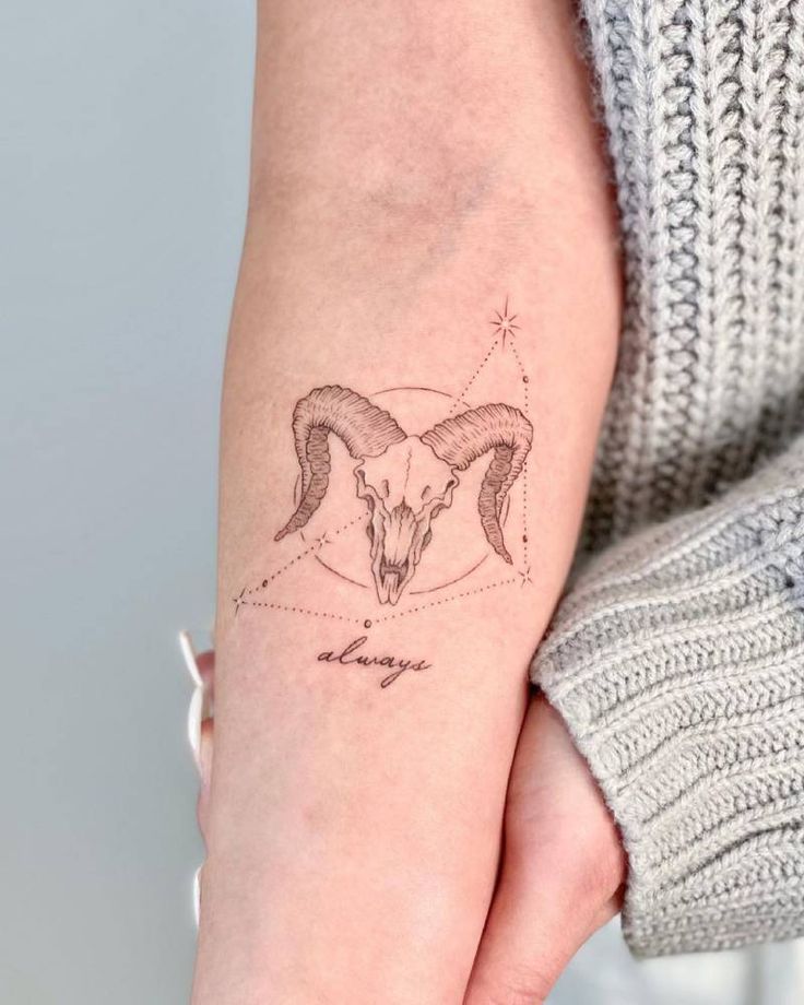 a woman's arm with a goat head tattoo on it