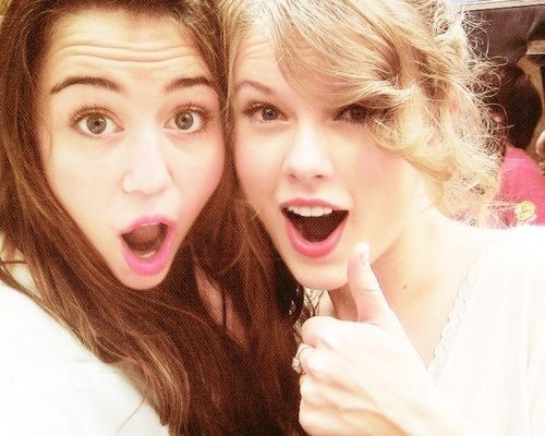 two young women posing for the camera with their mouths open and one pointing at the camera