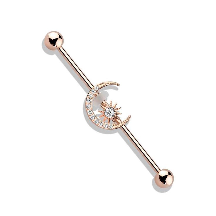 a rose gold barbell ring with a moon and star on the middle, set against a white background