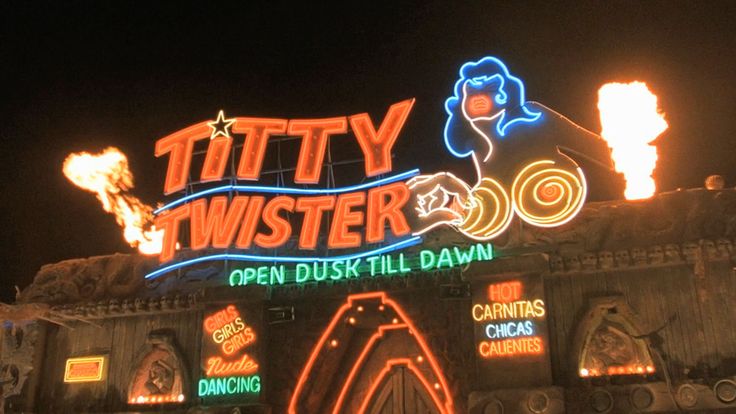 people are standing in front of a building with neon lights