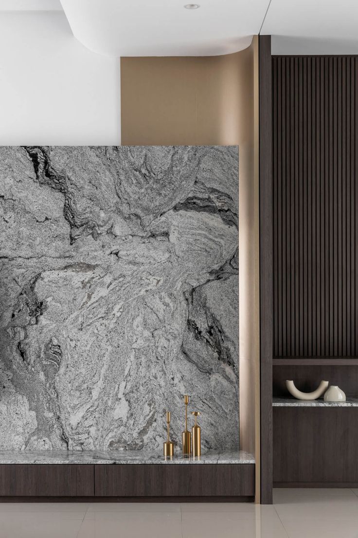 a bathroom with marble walls and flooring next to a shelf filled with vases