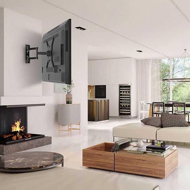 a living room filled with furniture and a flat screen tv mounted to the wall over a fireplace