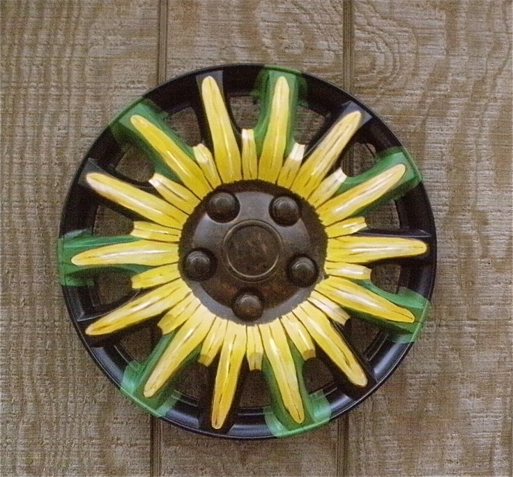 a black plate with yellow and green decorations on it's rim, sitting on a wooden surface