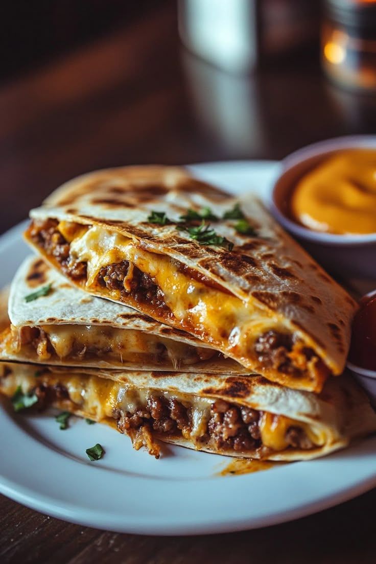 two quesadillas on a white plate with dipping sauce