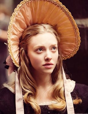 a young woman wearing a large hat on top of her head and looking off to the side