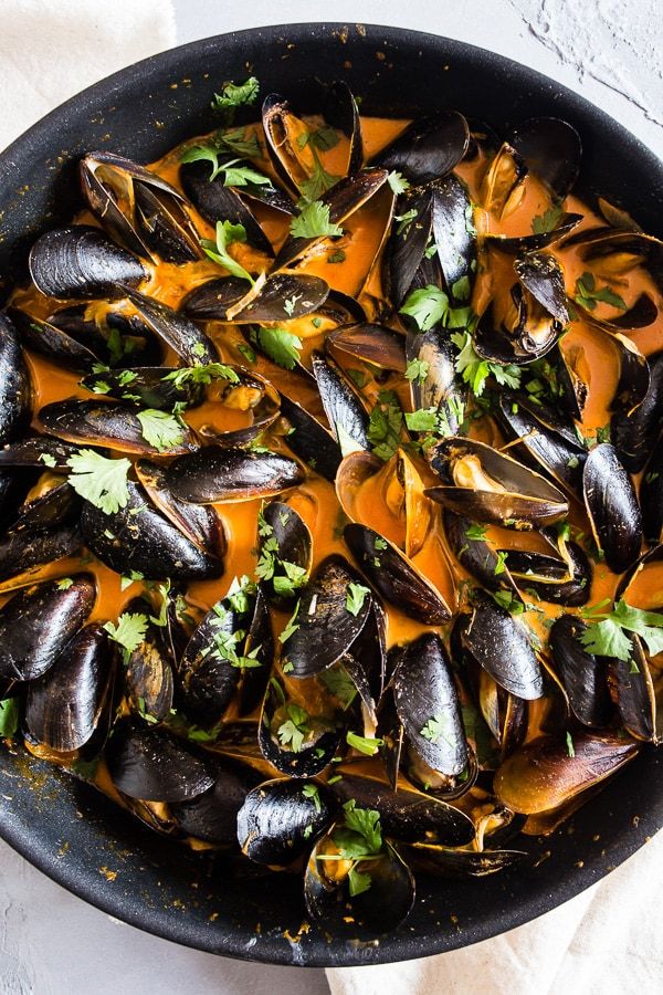 a skillet filled with steamed mussels and sauce