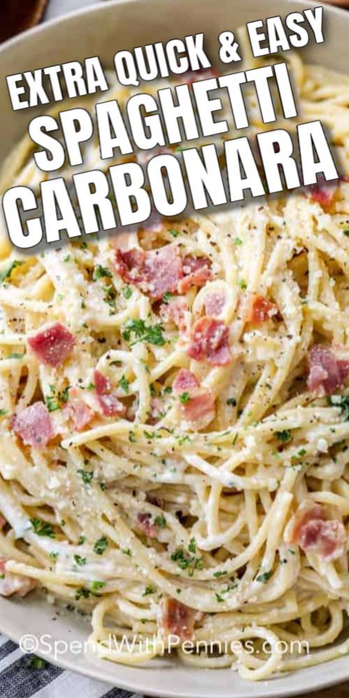 spaghetti carbonara with bacon and parsley in a white bowl on a checkered table cloth