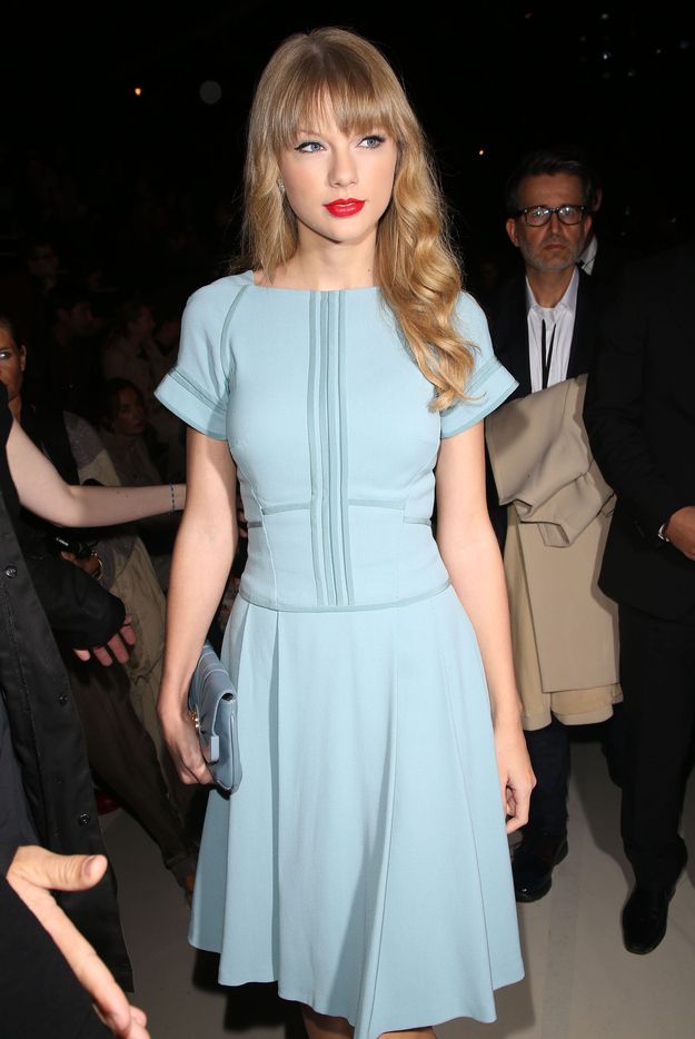 taylor swift is wearing a blue dress and red lips at the front row of a fashion show