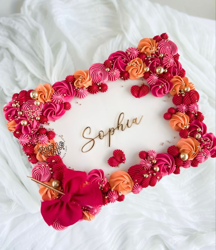 the name sophu is surrounded by pink and orange flowers on a white blanket