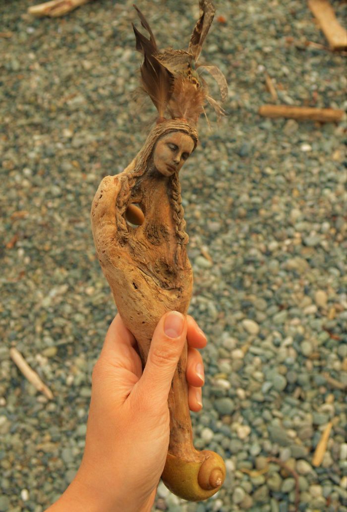 a person holding up a piece of food in their left hand, with other items on the ground behind them