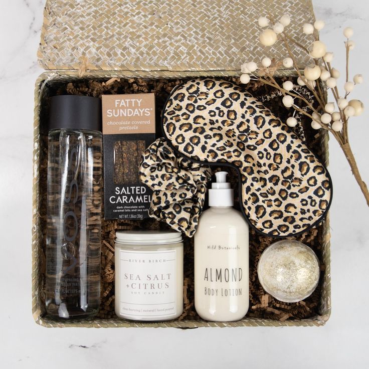 an open box containing body care products, and a leopard print scarf on a marble countertop