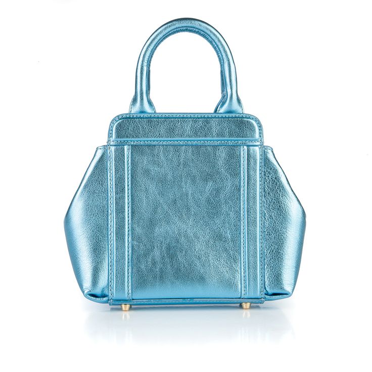 More to love in a mini. As the newest version of the iconic Nott handbag, this crowd favorite packs a punch. The Mini Nott can always be carried with its top handles or chain strap, and it always rises to the occasion – no matter the occasion. Dimensions: Height: 12.5 cm / 5 in Length: 18 cm / 7 in Depth: 4.5 cm / 1.75 in Removable, Gold Chain Strap: 125 cm Composition: Gold hardware accents Italian leather Interior: Custom artwork by: Artemis Antippas of New Orleans Snap closure Pocket Dust bag Blue Box Bag With Detachable Handle For Evening, Chic Blue Box Bag With Handles, Evening Blue Top Handle Satchel, Blue Top Handle Satchel For Evening, Modern Blue Box Bag With Double Handle, Blue Evening Bag With Top Carry Handle, Blue Evening Satchel With Handle Drop, Modern Blue Top Handle Bag, Blue Handheld Box Bag With Detachable Handle