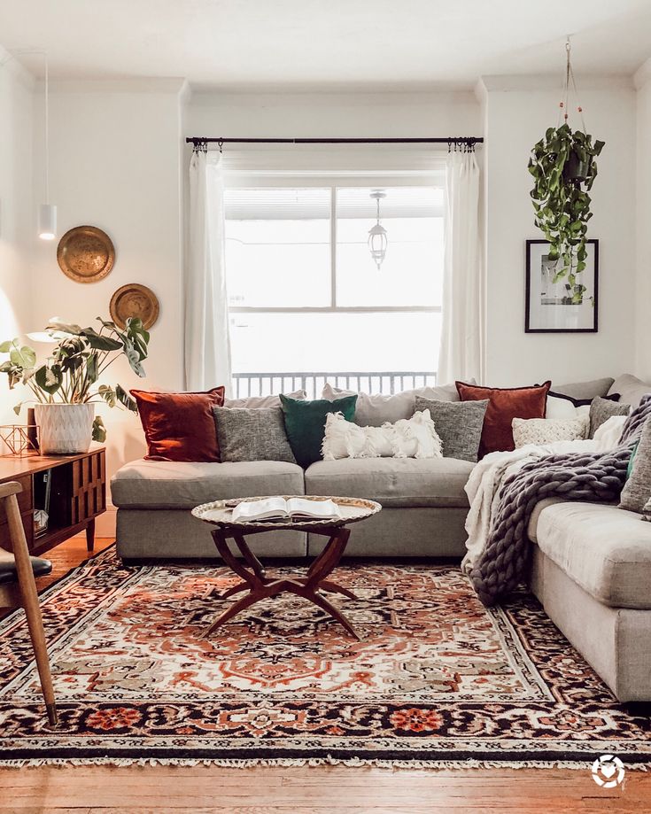 a living room filled with furniture and a large rug on top of a hard wood floor