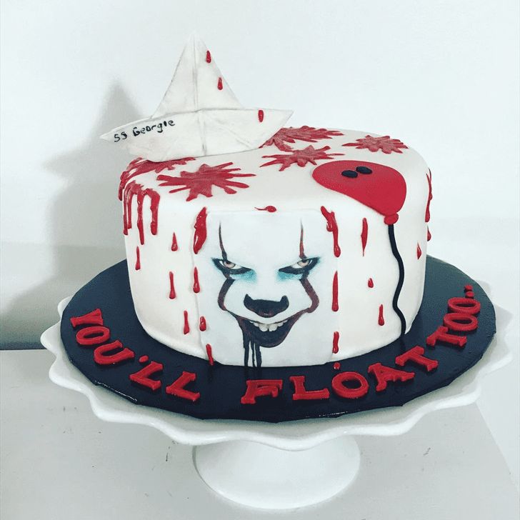 a white cake with red and black icing on it's face is sitting on a platter