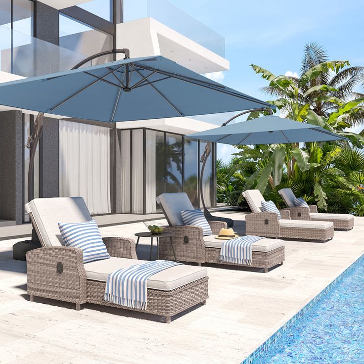 an outdoor pool area with lounge chairs and umbrellas