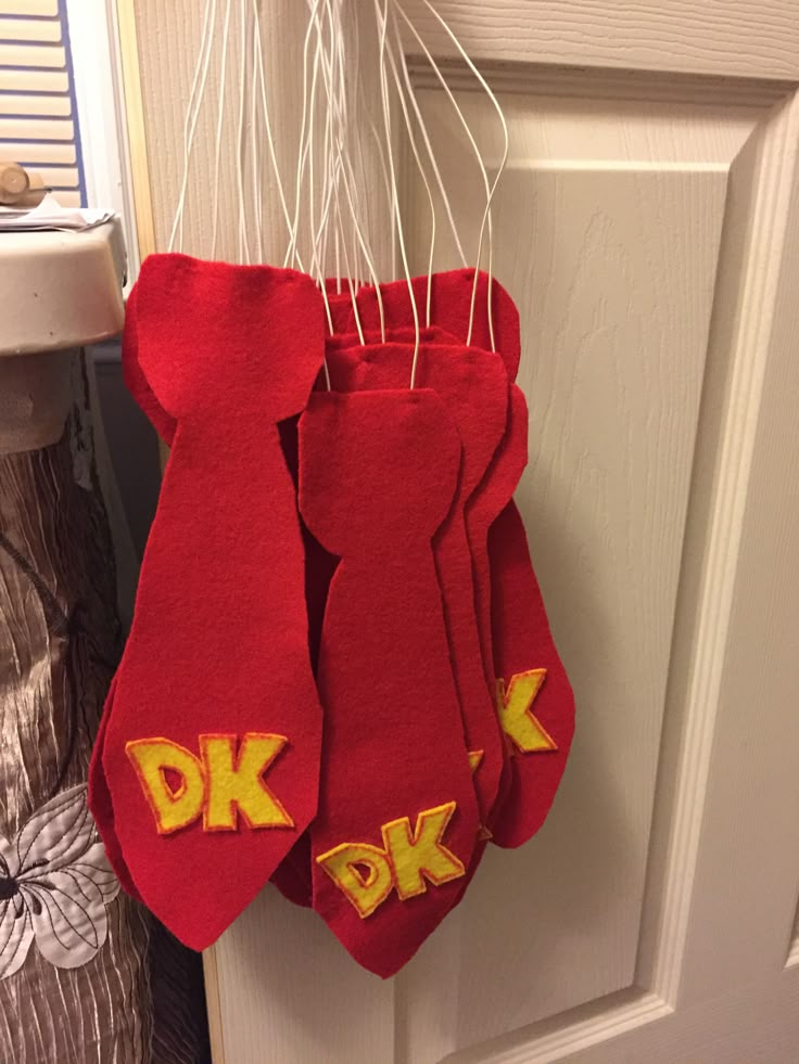 two red socks hanging from a hook on a door