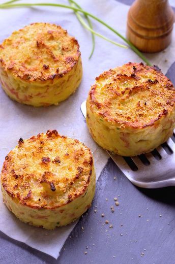 three baked mashed potatoes sitting on top of a table next to a spatula