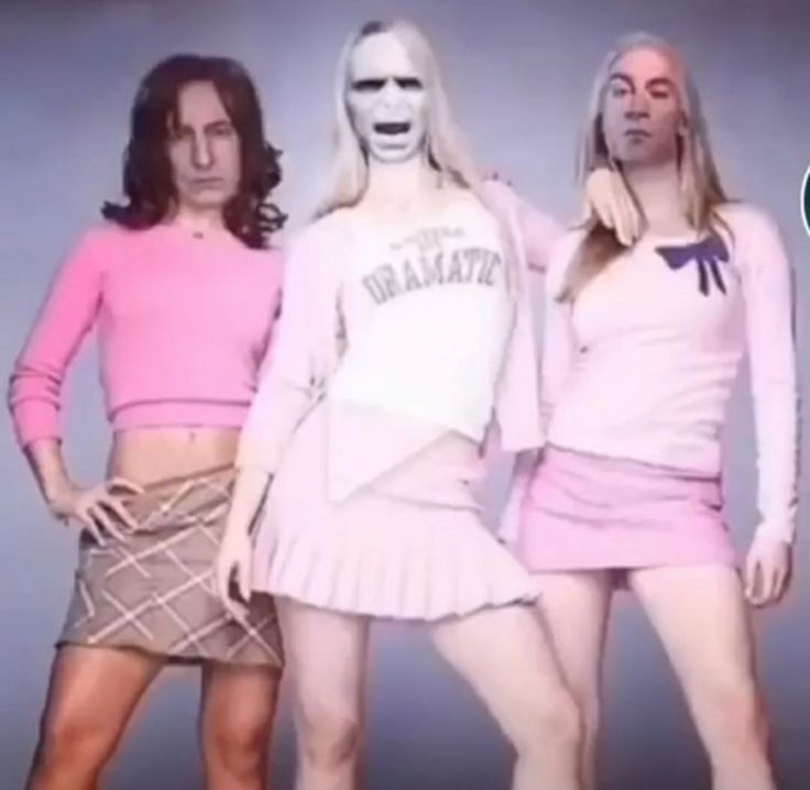 three women in skirts and sweaters standing next to each other with their mouths open