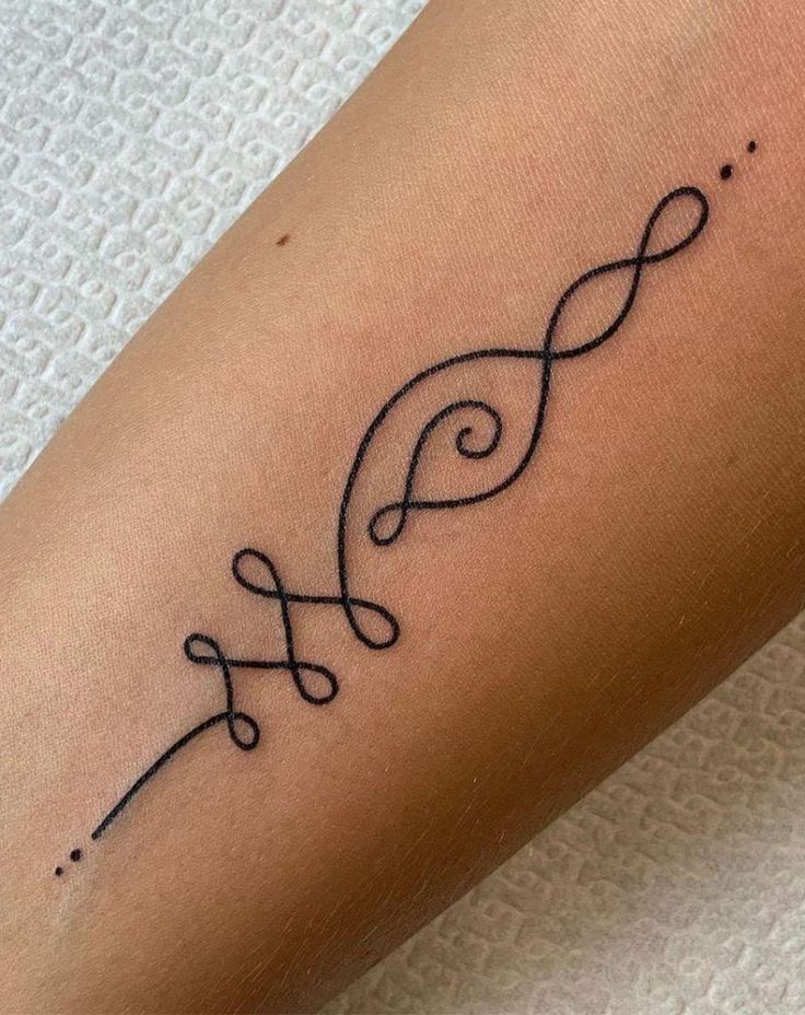 a small tattoo on the leg of a woman with an infinite symbol in black ink