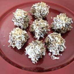 six pieces of chocolate truffle on a red plate with white sprinkles