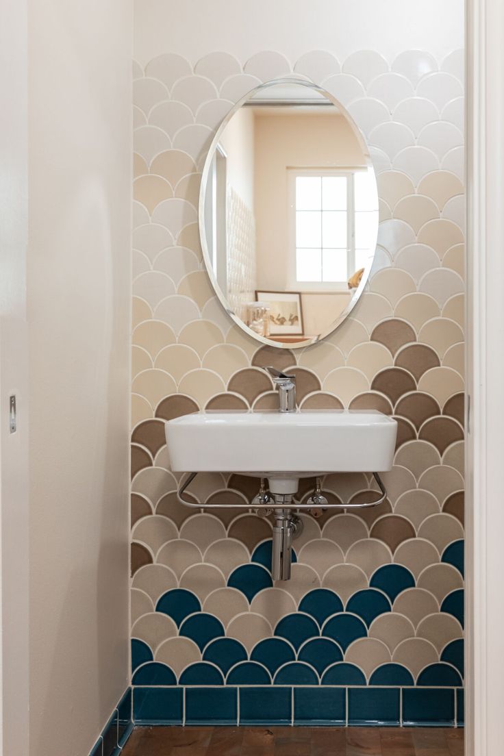 a bathroom with a sink, mirror and tiled flooring in it's walls