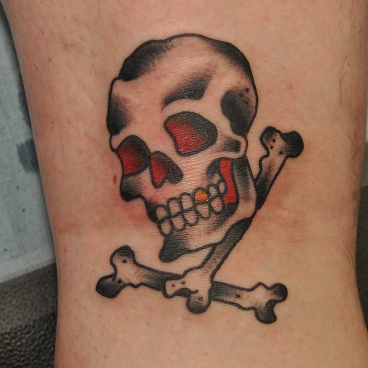 a skull and crossbone tattoo on the ankle