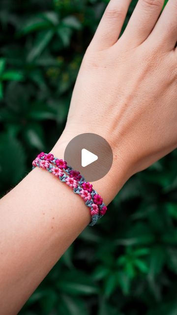 a woman's hand wearing a pink and blue bracelet