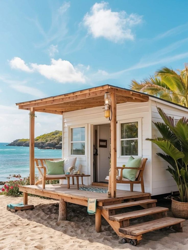 a small house on the beach with steps leading up to it's front door