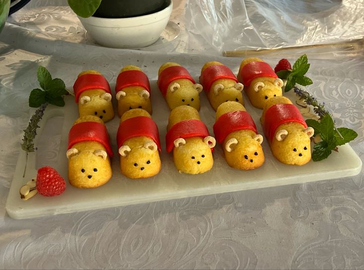 there are many little pigs in hats on the plate with strawberries and raspberries