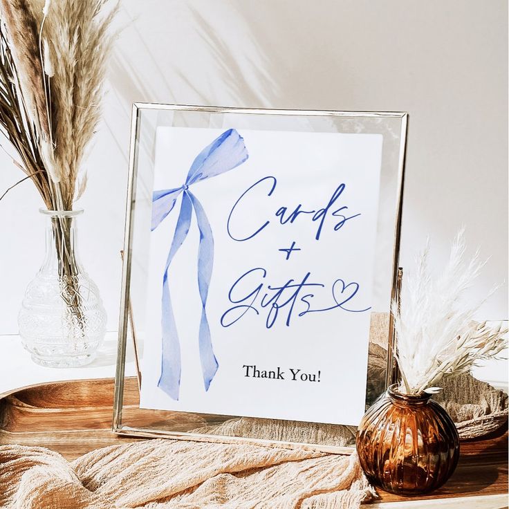 a sign that says cards and gifts on it next to a vase with dried grass