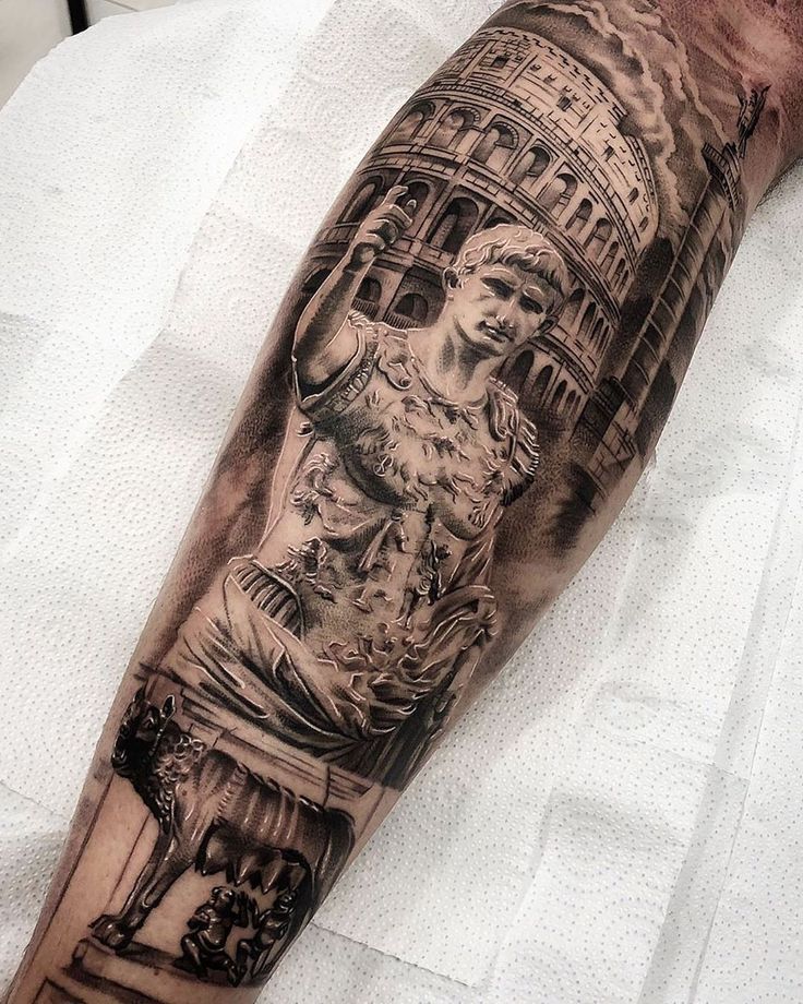 a man's arm with a statue on it