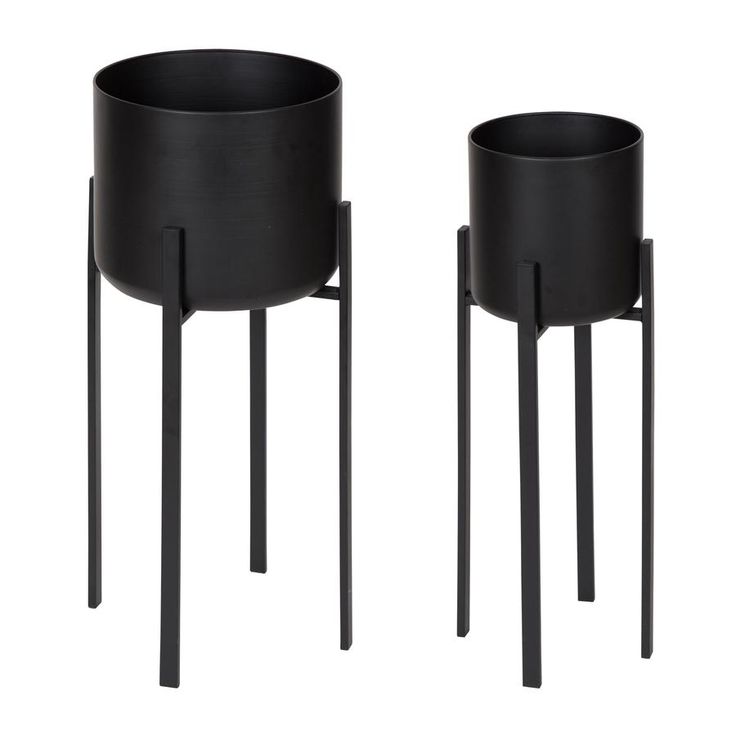 two black planters sitting next to each other on top of metal legs and bases