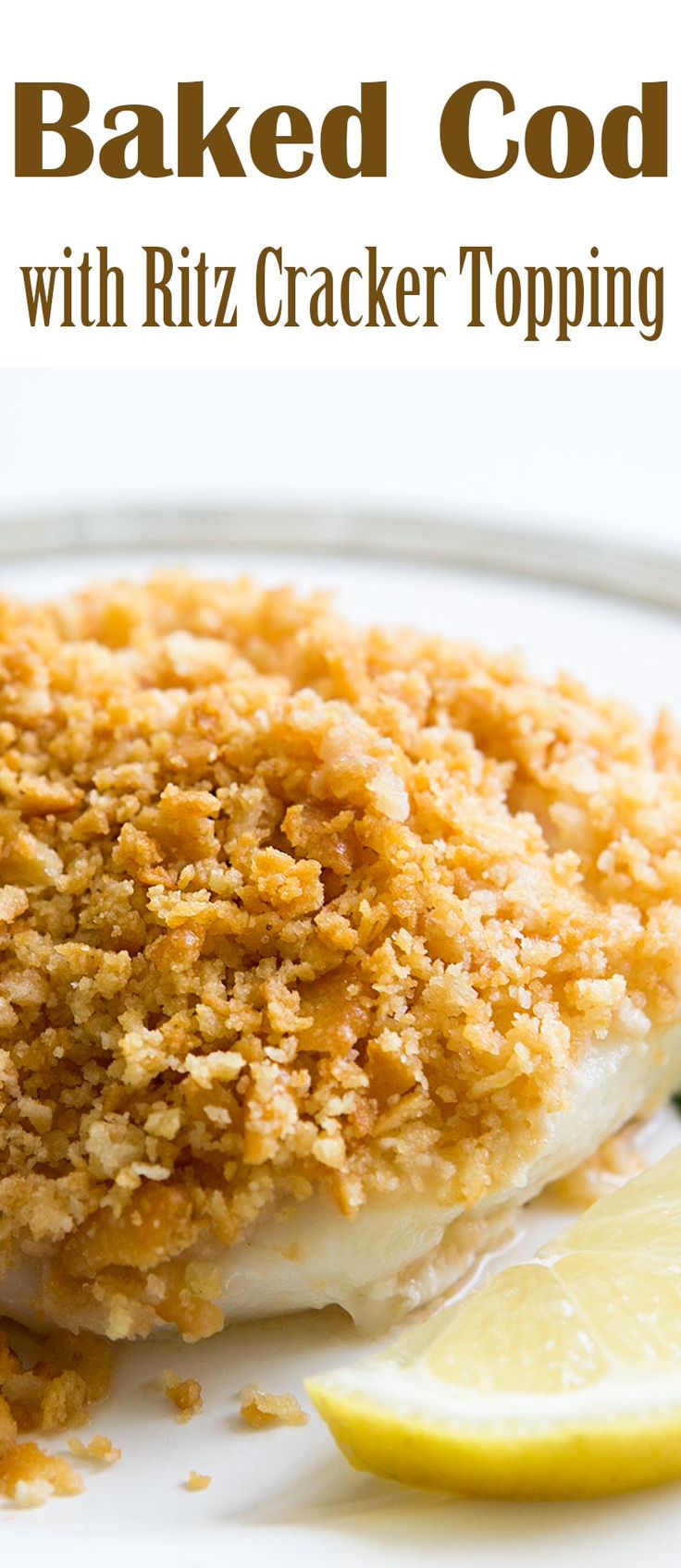 baked code with ritz cracker topping on a white plate next to lemon wedges