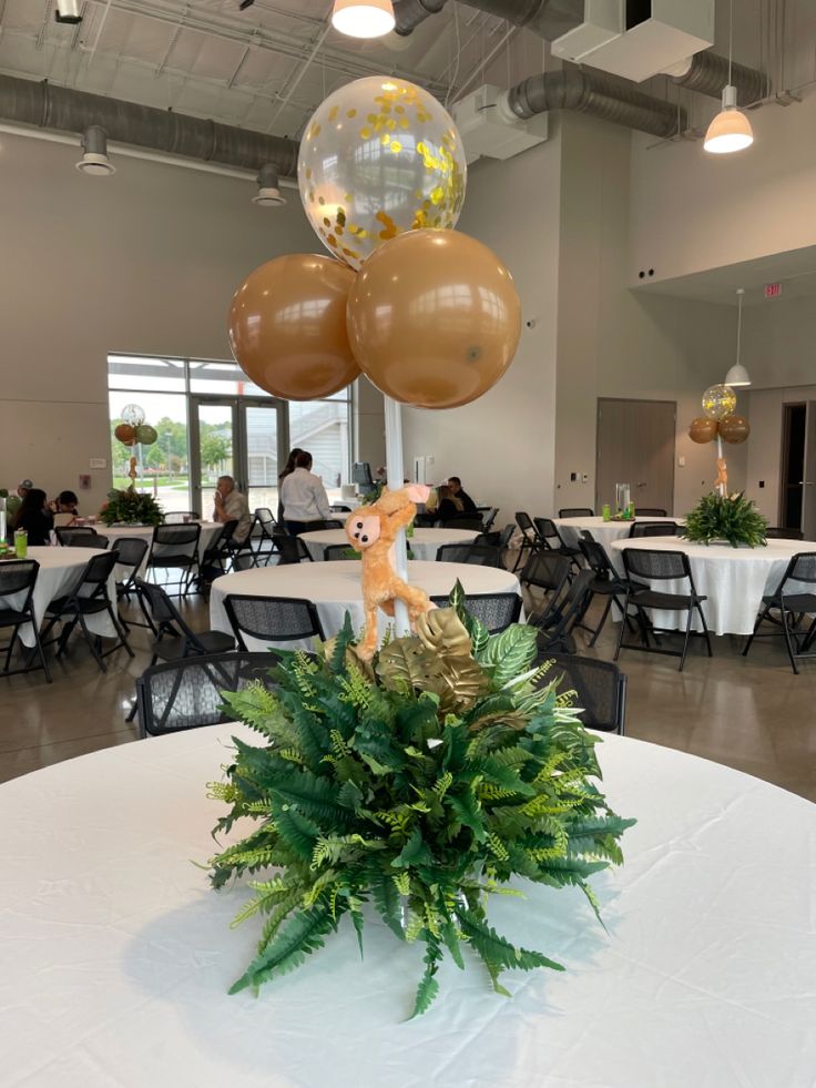 a table topped with balloons and a deer figurine sitting on top of it