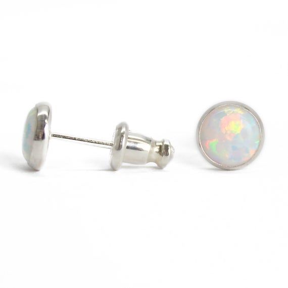 These opal stud earrings are beautiful.  They feature a single 6mm simulated opal cabochons.  Hand bezel set in my studio.  6mm Simulated Opal Round CabochonsSolid 925 Sterling Silver or 14/20 Gold FilledDeluxe Luxlock Backs-Safe, Secure, ComfortableArtisan Made in TexasArrives thoughtfully packaged in a signature jewelry boxCheck out all of my opal earrings: https://www.etsy.com/shop/KMBankston/search?search_query=opal+earring&order=date_desc&view_type=gallery&ref=shop_search~About Elegant Nickel-free Opal Ring For Gift, Classic Opal Cabochon Jewelry, Iridescent Opal Cabochon Jewelry, Minimalist Iridescent Round Jewelry, Elegant Hypoallergenic Opal Jewelry, White Hypoallergenic Opal Jewelry, Ethiopian Opal Birthstone Jewelry, Hypoallergenic White Opal Jewelry, Adjustable Round Opal Jewelry