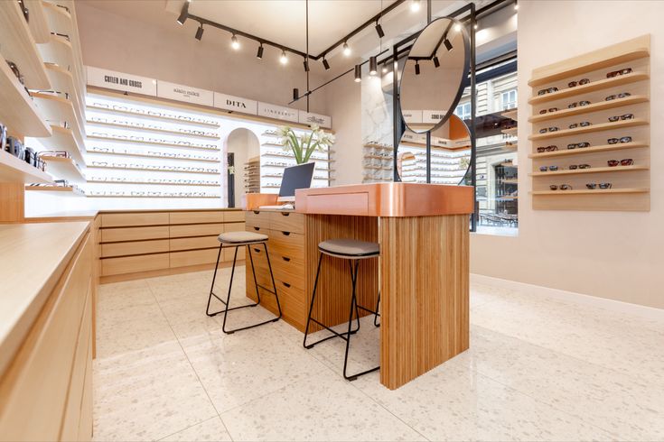 the inside of a shoe store with lots of shelves and stools on each side