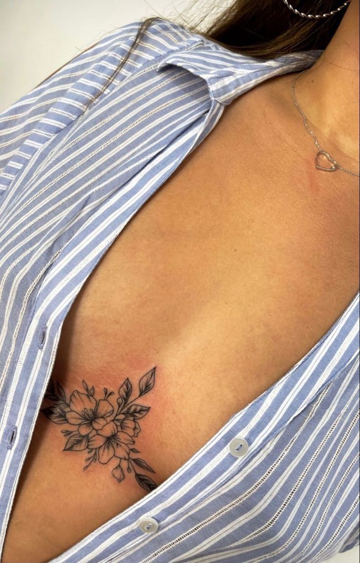 a woman's chest with a flower tattoo on her left shoulder and right breast