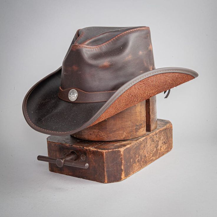 Welcome the Western Leather Cowboy Hat! This workhorse of a Cowboy hat is a dream. Handcrafted from a lightweight top grain leather will wear as if it is not there. Textured topgrain cowhide construction Boldly curved and classic shape Made in California, USA Brim 3" Crown 4" Size 6 up to a Size 8 Removable Sweatband Cowhide Leather Featherweight Buffalo Nickel Hat Band Sizing Info Measuring for the Western - Mens American Leather Cowboy Hat begins by wrapping a soft measuring tape (also known a Straw Cowgirl Hat, White Cowboy Hat, Brown Cowboy Hat, Hats For Big Heads, American Hat Makers, Leather Cowboy Hats, American Hat, Black Cowboy Hat, Outback Hat