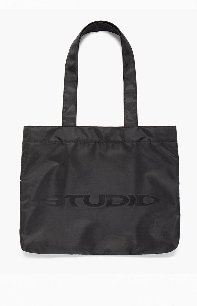 Studio by Supervsn introduces their classic Tote Bag to keep everything you need in one place. With a roomy main compartment, mesh zipper pouch, and iconic logo graphic, this tote bag makes for a functional and cool piece for your streetwear style. 


	Solid color tote bag
	Fixed straps
	Roomy main compartment
	Snap-button closure
	Mesh zipper pouch
	Logo graphic


4% of net proceeds from each Studio Powered by Supervsn product purchased will be donated to the Living Through Giving Foundati Black Tote Bag With Logo, Black Logo Bag For On-the-go, Black On-the-go Bag With Logo, Black On-the-go Bags With Logo, Nylon Bags With Logo For Daily Use, Nylon Logo Bags For Daily Use, Logo Shoulder Bag For On-the-go, Practical Nylon Bags For Streetwear, Practical Nylon Streetwear Bags