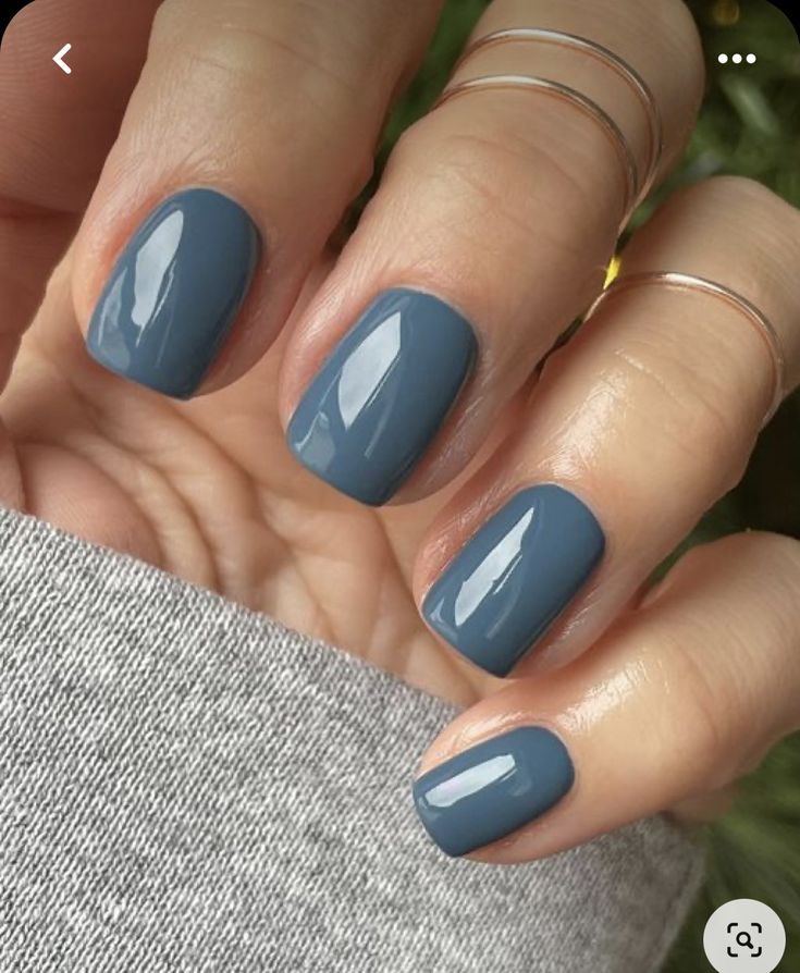 a woman's hand with blue nail polish on it