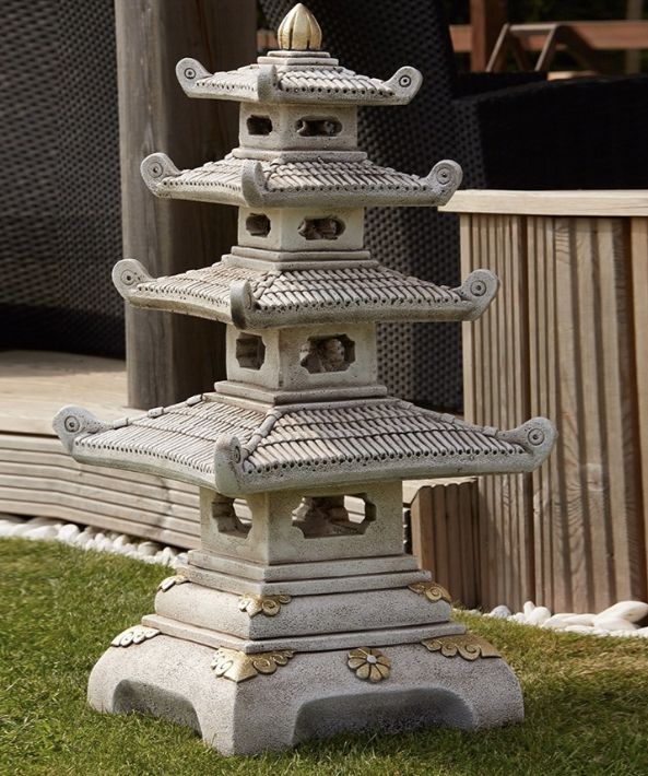 a stone pagoda sitting on top of a lush green field