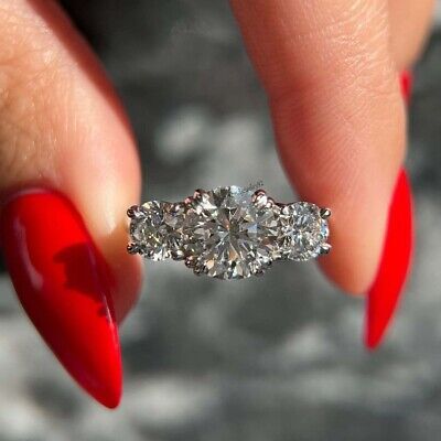 a woman's hand with red fingernails and a diamond ring on her finger,