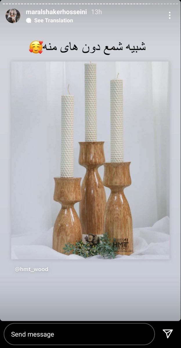 three wooden candles sitting next to each other on top of a white sheeted table